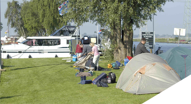 Tenten opzetten aan het water bij camping Friesland