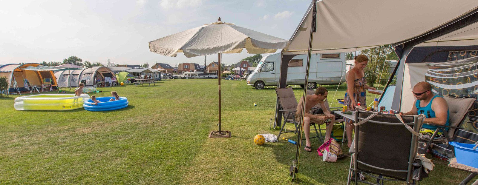 Kamperen bij camping Friesland aan het water met tent en caravan
