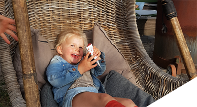 Kindje in de hangstoel op terras de Koken onder het genot van een ijsje.